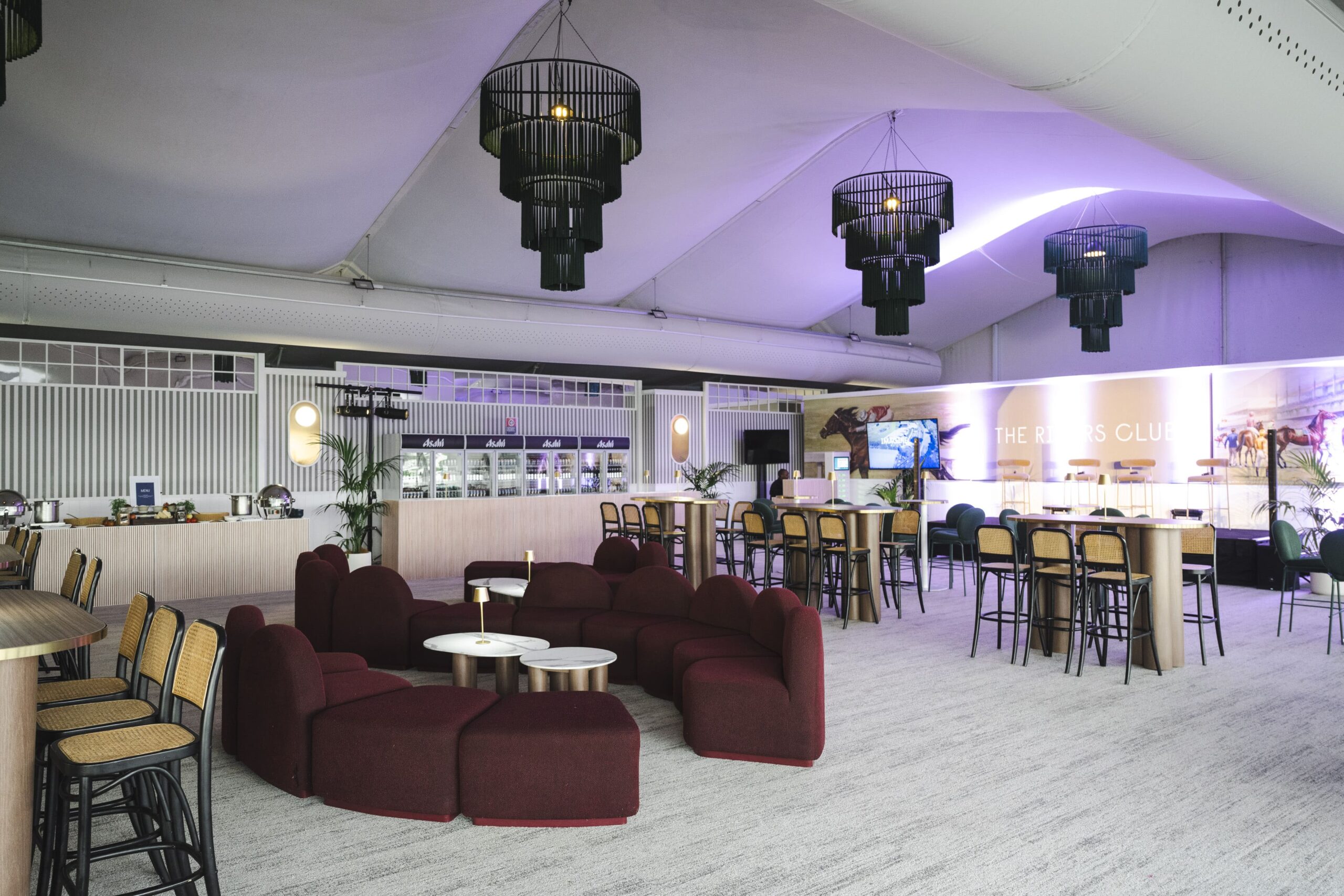 An empty function room and bar at a racecourse showing seating and light fittings