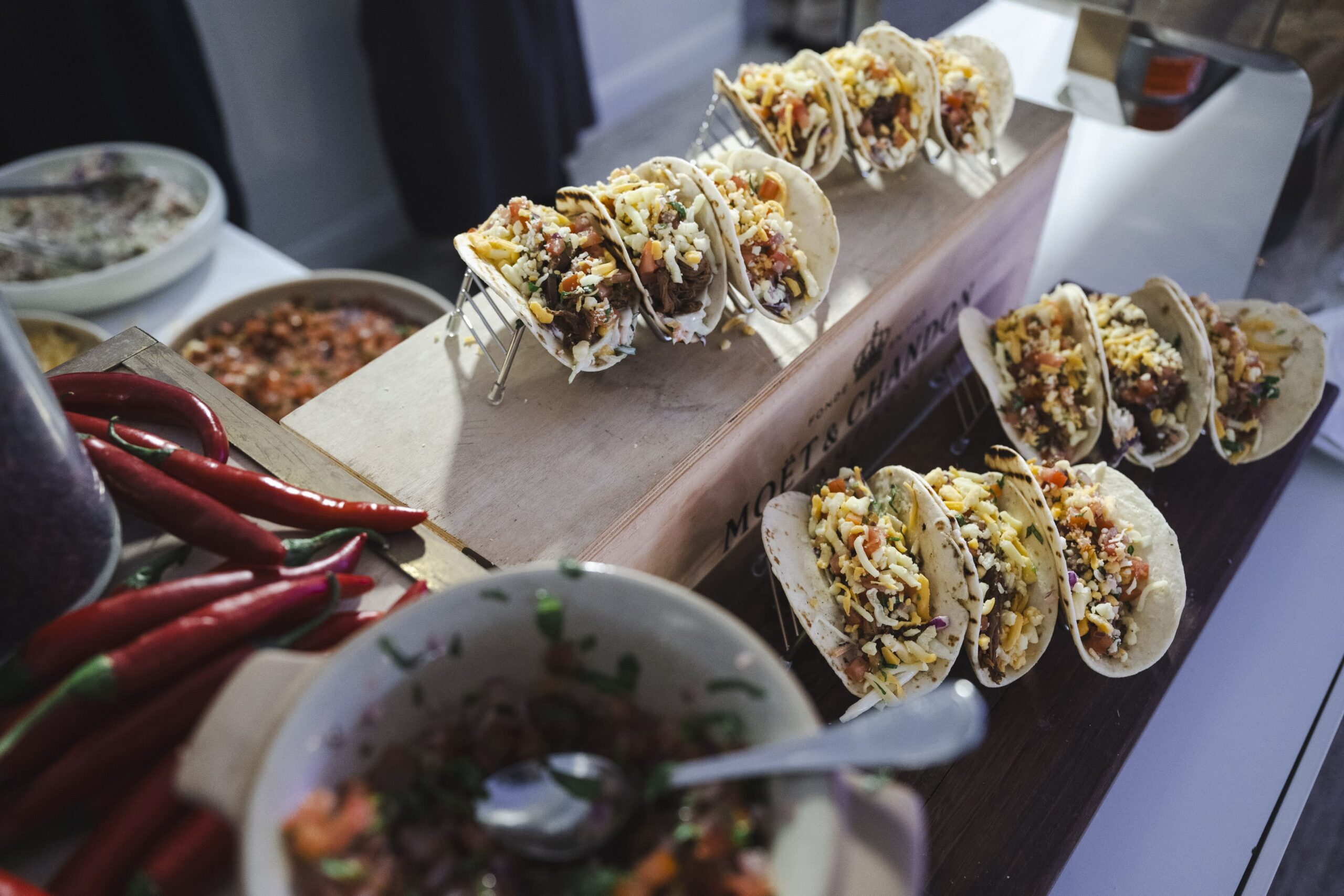 A Mexican themed culinary display with tacos being served